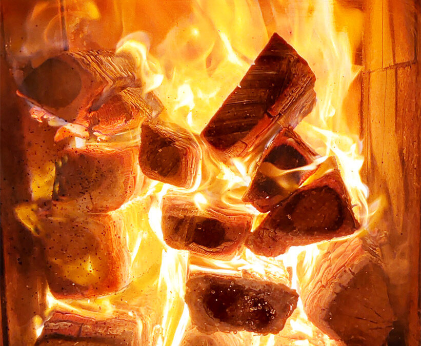 Brennendes Holz im Feuerraum eines Grundofens.