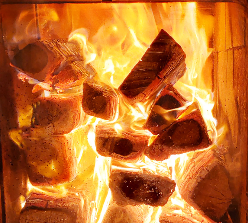 Brennendes Holz im Feuerraum eines Grundofens.